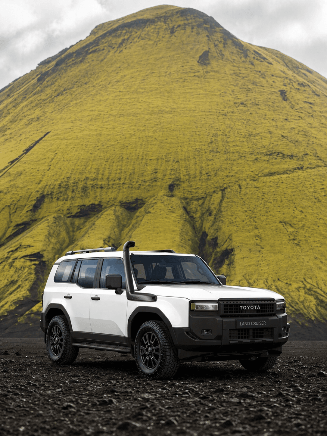 White Toyota Land Cruiser 4×4 with snorkel in front of a green volcanic peak